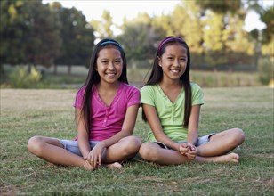 Asian twin girls smiling outdoors