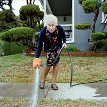 Woman watering her front lawn