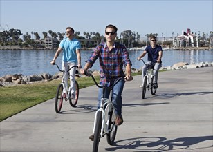 Men riding bicycles at waterfront