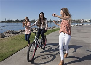Women running and bike riding at waterfront