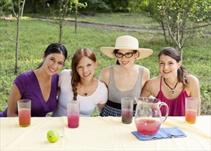 Women drinking juice outdoors at table