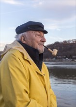 Older Caucasian fisherman near water