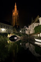 Church and buildings along canal at night