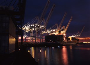 Illuminated cranes over commercial dock at night