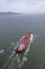 Aerial view of container ship in urban harbor