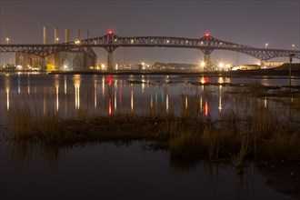 Reflection of illuminated bridge in still lake