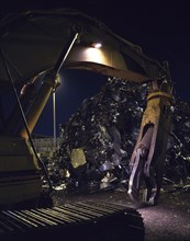 Mechanical grabber in junkyard at night