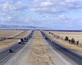 Cars and semi-trucks driving on freeway