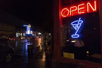 Neon sign in bar window at night