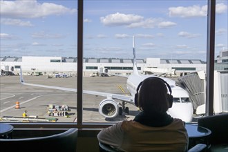 Passenger listening to headphones at airport