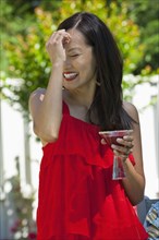 Asian woman enjoying martini outdoors