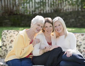 Three generations of Caucasian women smiling outdoors