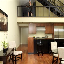Asian woman standing on second level of loft