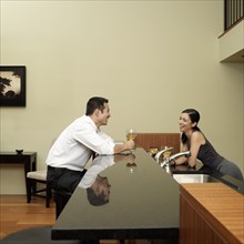 Asian couple talking in kitchen