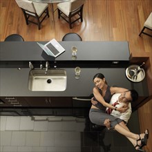 Asian man carrying wife in kitchen