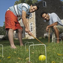 Mixed race men playing croquet