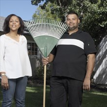 Couple standing in yard with rake