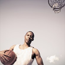 African American man holding basketball on court