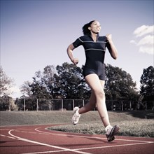African American woman running on track