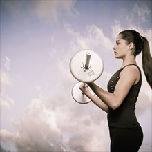 Woman using lifting weights outdoors