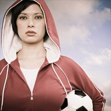 Mixed race woman carrying soccer ball