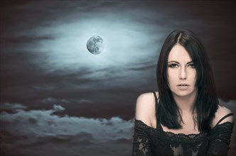 Caucasian woman in front of full moon
