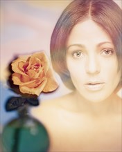 Digital composite of woman's face and rose