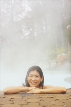 Asian woman sitting in hot tub