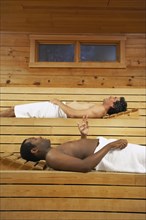 Two multi-ethnic men relaxing in sauna