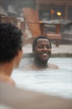 Two multi-ethnic men sitting in hot tub