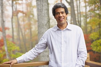 Man standing on deck in woods