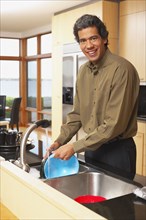 Man washing dishes in kitchen