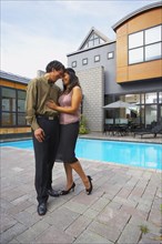 Couple hugging in front of house