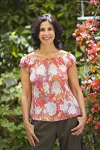 Confident Middle Eastern woman standing in garden