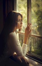 Caucasian woman daydreaming at window