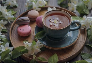 Flowers on tray with tea and macaroons