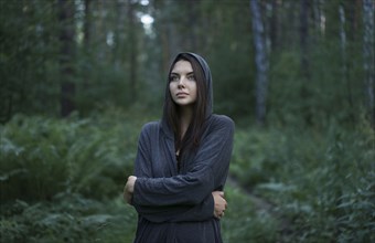 Cold Caucasian woman standing in forest