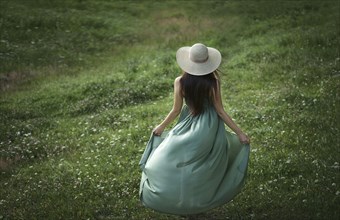 Caucasian woman wearing green dress in field