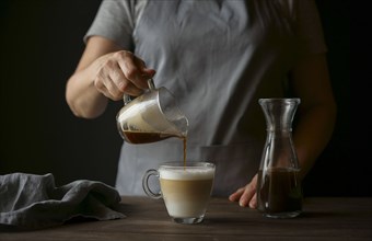 Caucasian woman pouring coffee into latte