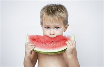 Caucasian boy biting watermelon slice