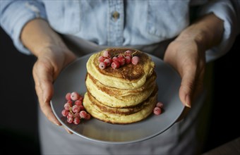 Close up of Caucasian woman holding plate of pancakes