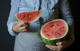 Close up of Caucasian woman holding slice of watermelon