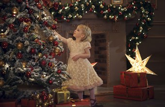 Caucasian girl decorating Christmas tree