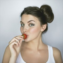 Caucasian woman kissing strawberry