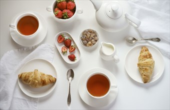 Tea with croissants and strawberries