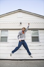 Mixed race boy jumping in mid-air