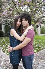 Couple hugging near tree with spring blossoms