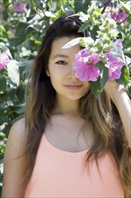 Asian woman hiding behind flower