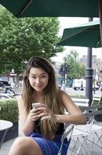 Asian woman using cell phone outdoors