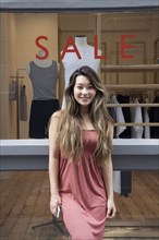 Asian woman standing outside store